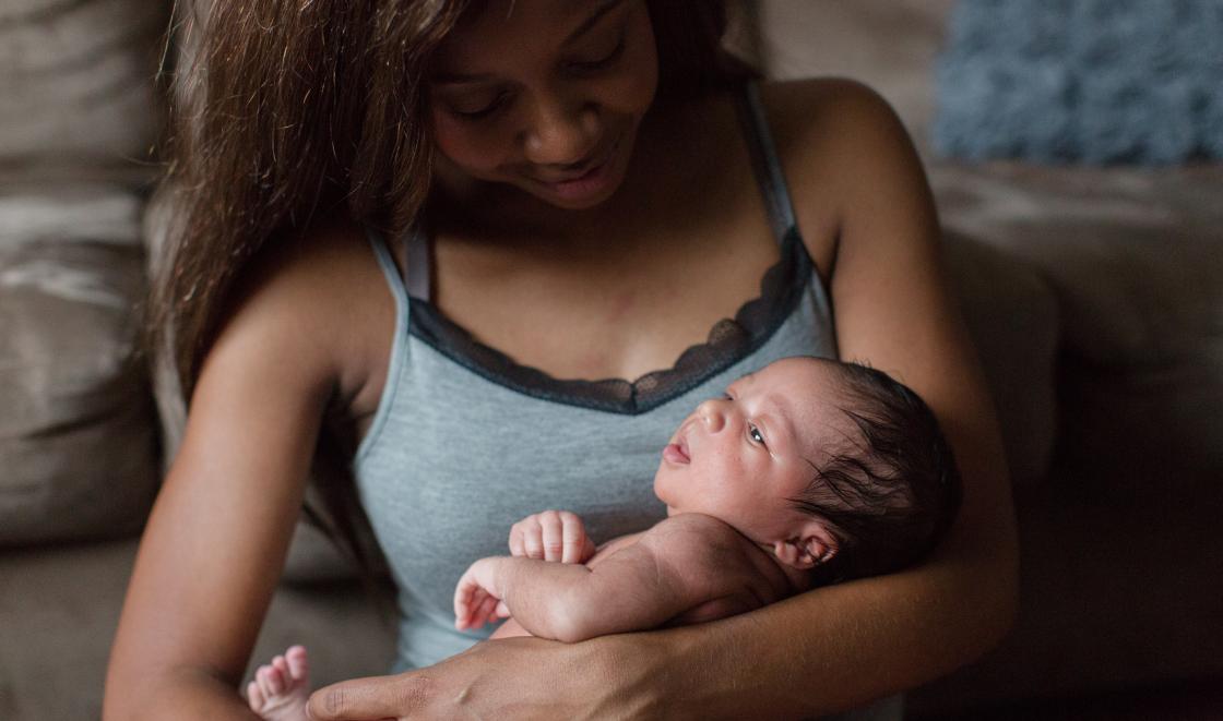 Black mother carrying baby
