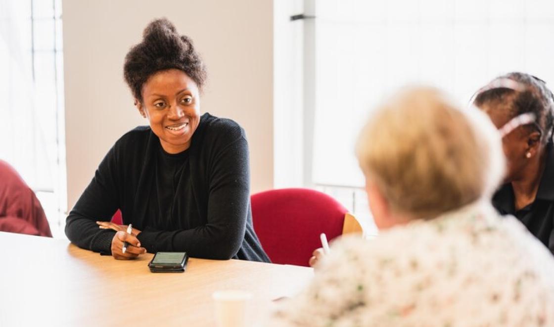 Black woman and white woman talking at table